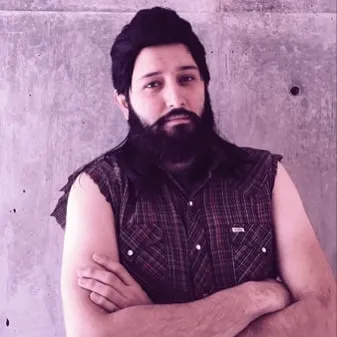 A portrait of a man with a dark beard and hair, wearing a dark plaid shirt, positioned against a heavily textured, mottled gray background.