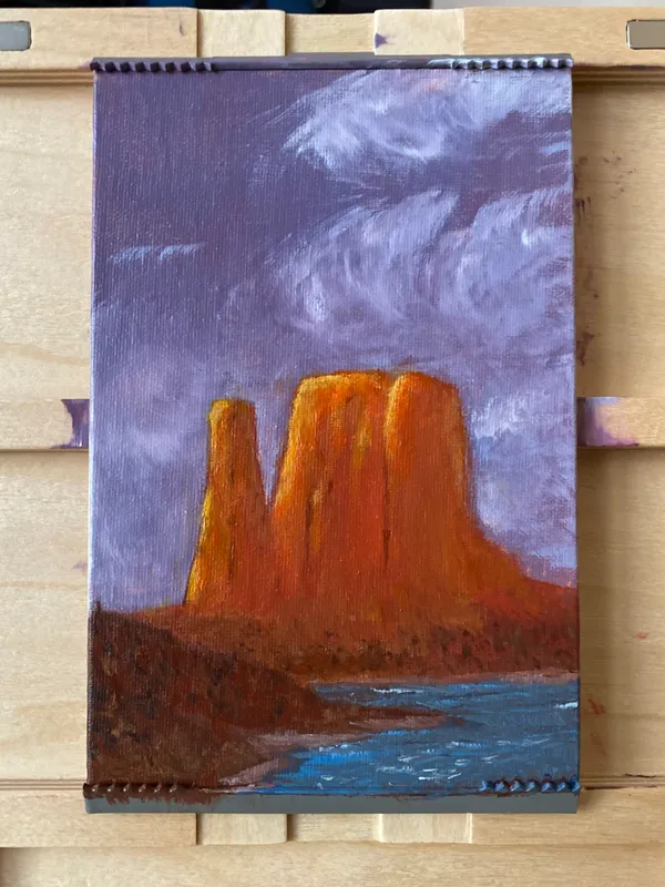 Large, reddish-orange rock formations dominate the center, set against a turbulent sky of purple and gray, with visible brushstrokes in the swirling clouds and blue water below.