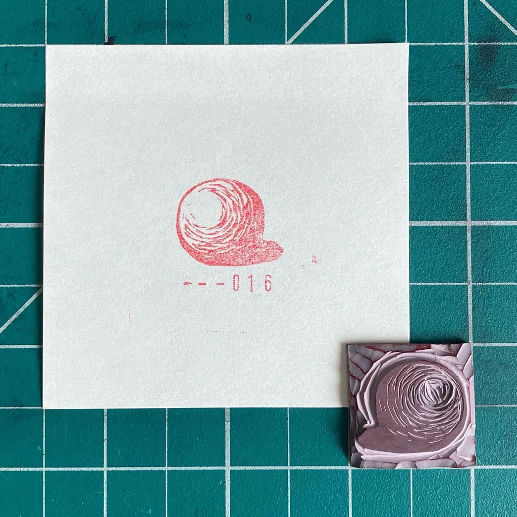 A white card on a teal grid features a reddish-pink coiled drawing and the number 016, alongside a small, textured square displaying a deep spiral pattern.
