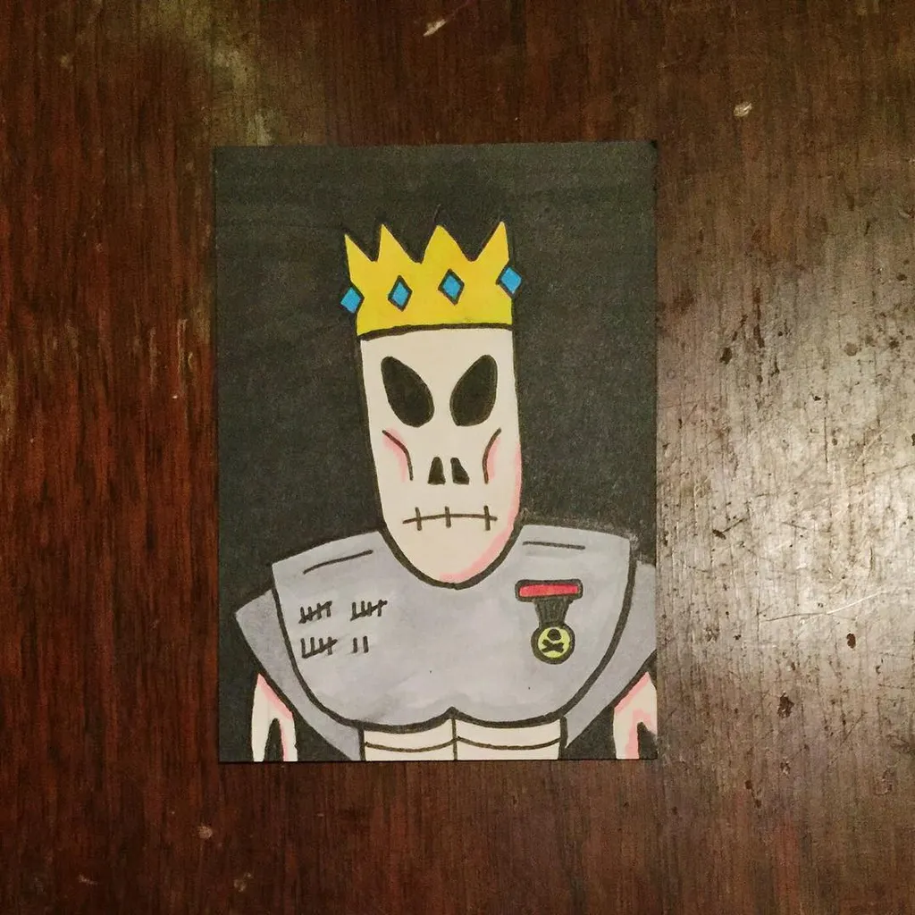 A stylized skull wearing a yellow and blue crown and a gray tunic is drawn on a dark square, positioned on a reddish-brown wooden surface.