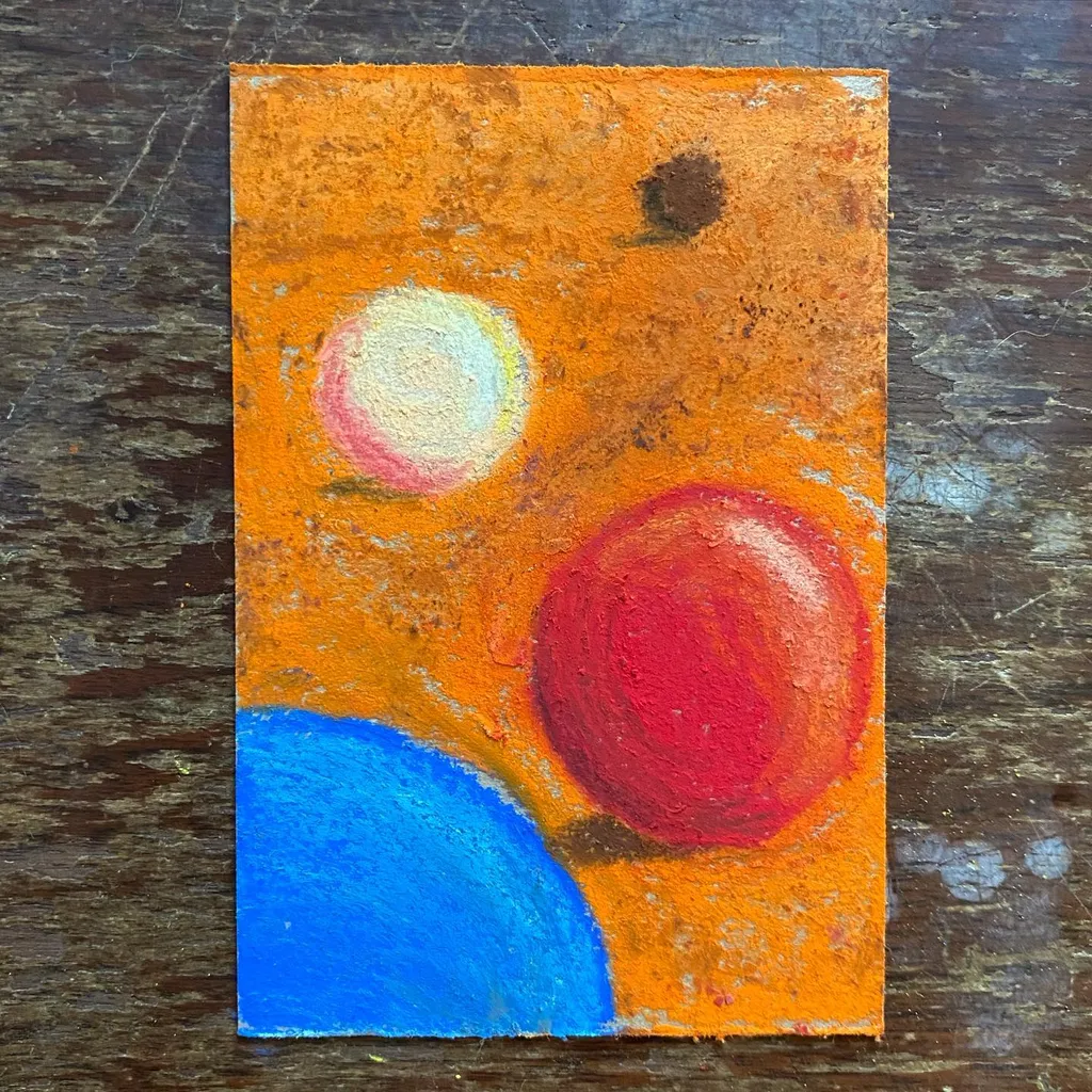 The composition features large blue and red circles against a textured orange background, accented by a smaller white circle and dark smudges.