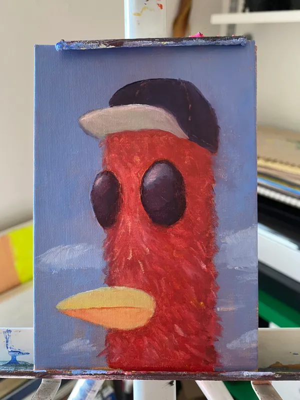 A stylized red creature with large black eyes and a yellow beak stands against a light blue background featuring white cloud strokes, wearing a black hat with a white band.