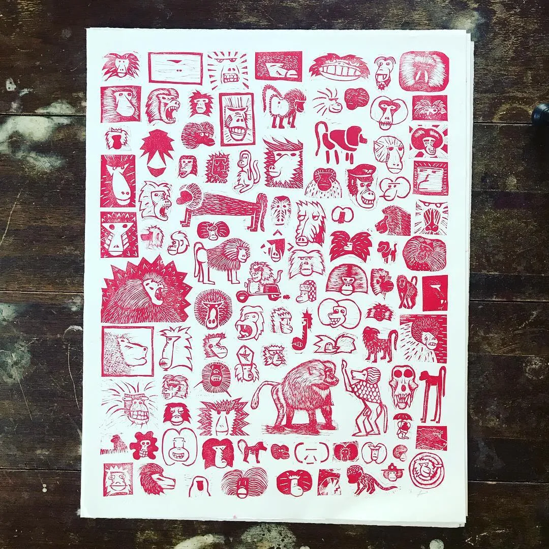 A dense, rectangular composition of red markings on white paper, featuring repeating stylized depictions of animals, faces, and abstract symbols arranged in a structured grid.