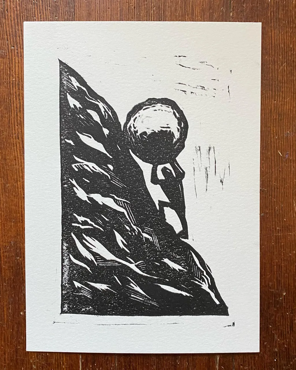 A black and white print features a stylized profile portrait emerging from a dense, jagged mass of sharp, geometric lines that fills the left side.