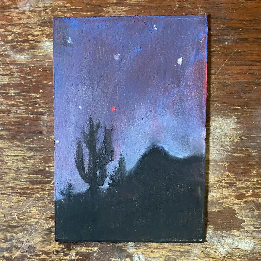 A vertical landscape features a dark foreground silhouette against a deep blue and purple sky that fades upward, marked with small white and colored specks.