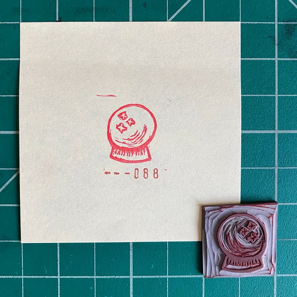 A cream card on a teal grid background displays a red stylized drawing of a coiled object and the numbers 088, next to a small square object featuring layered pink and white coiled material.
