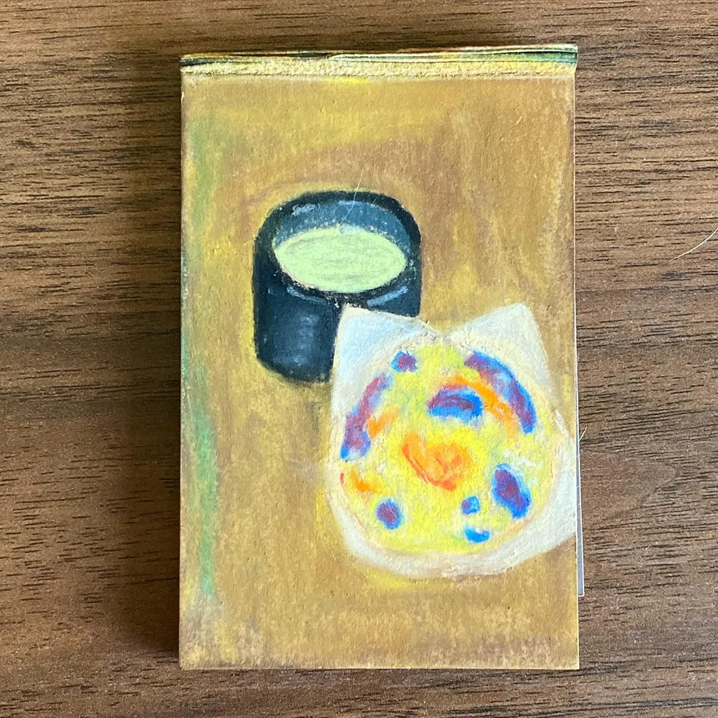 On a mustard yellow background, a dark, circular object sits above a white, irregular shape speckled with bright yellow, orange, and blue spots, rendered with visible brushstrokes.