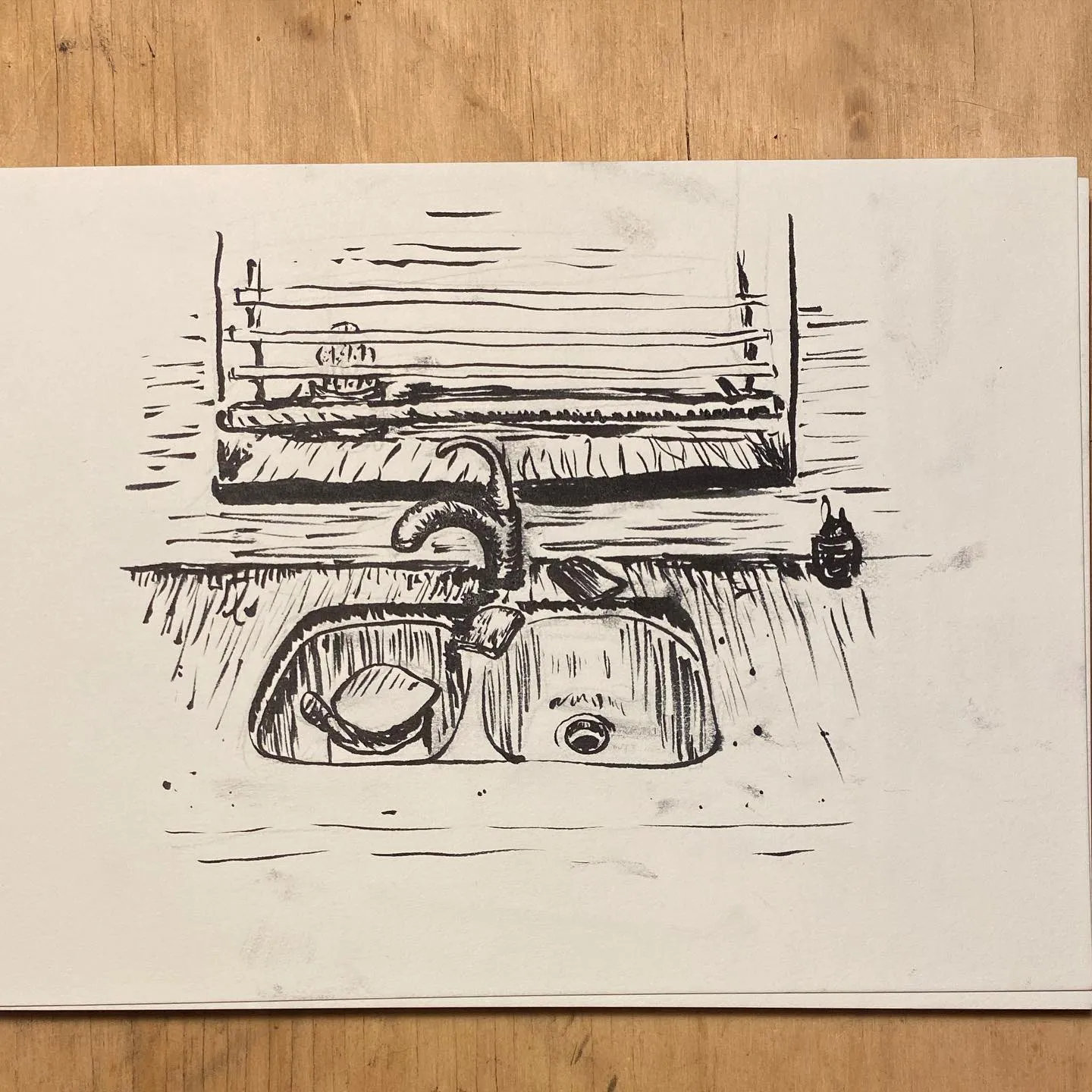 A black and white sketch depicts a wash basin set into a counter, featuring a curved faucet and visible drain opening, rendered with loose, sketchy lines.