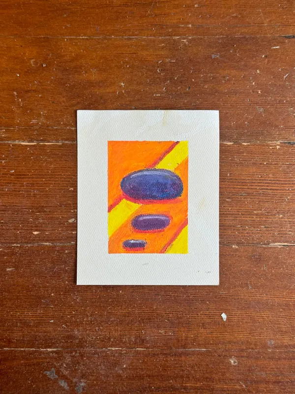 The artwork is centered on a wooden surface, showing vertical bands of orange and yellow intersected by two horizontal ovals: a large dark blue one and a smaller purple one.