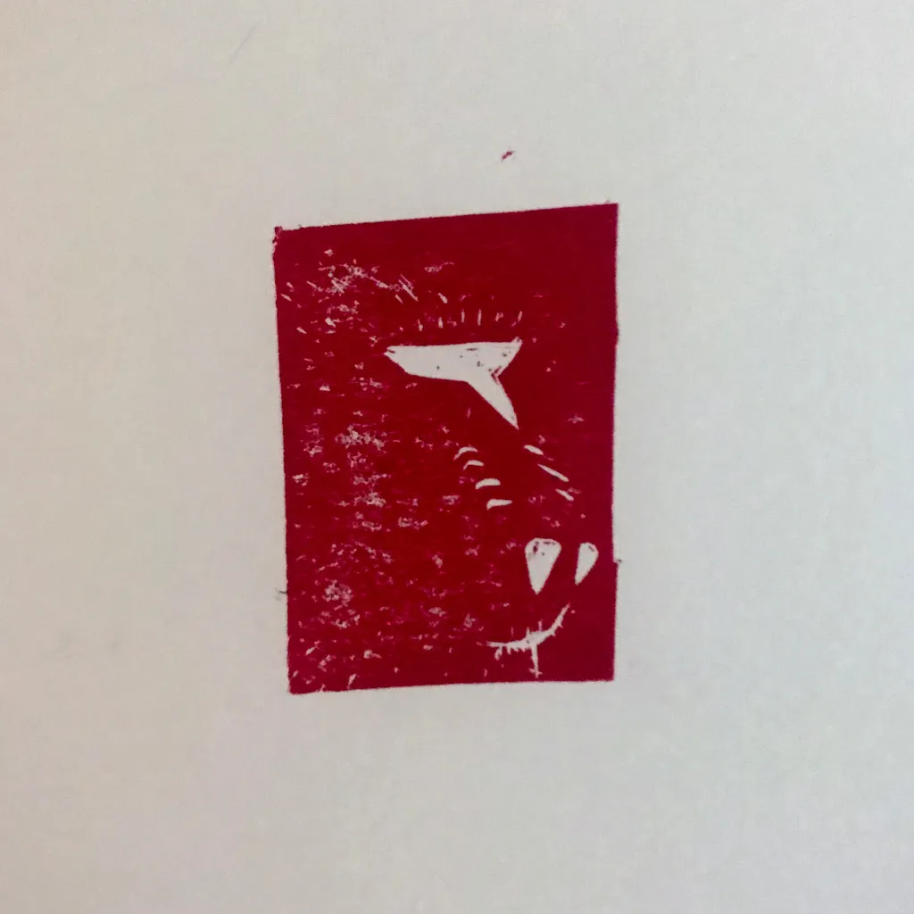 A deep red square block contains a white, stylized profile of an animal head, featuring an ear, eye, and snout.