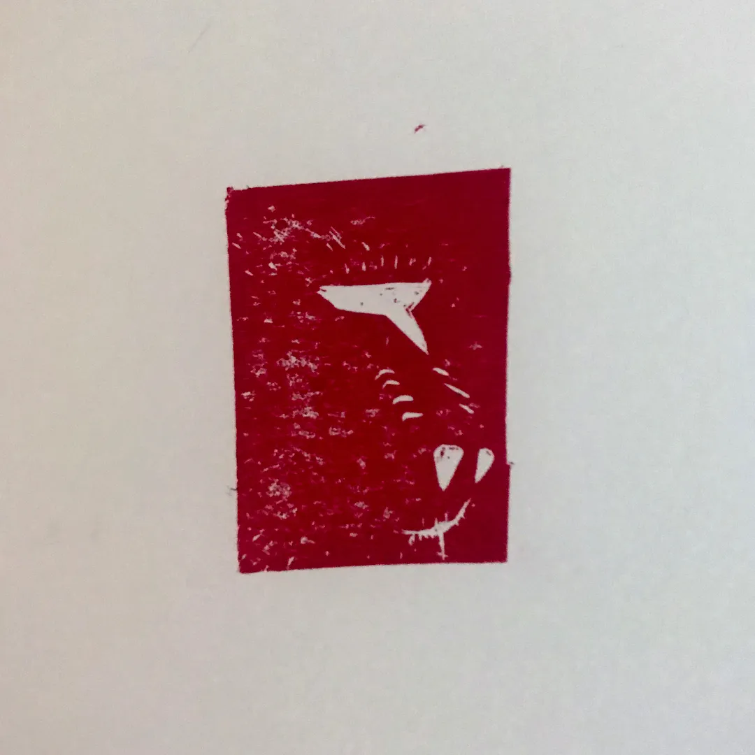 A deep red square block contains a white, stylized profile of an animal head, featuring an ear, eye, and snout.