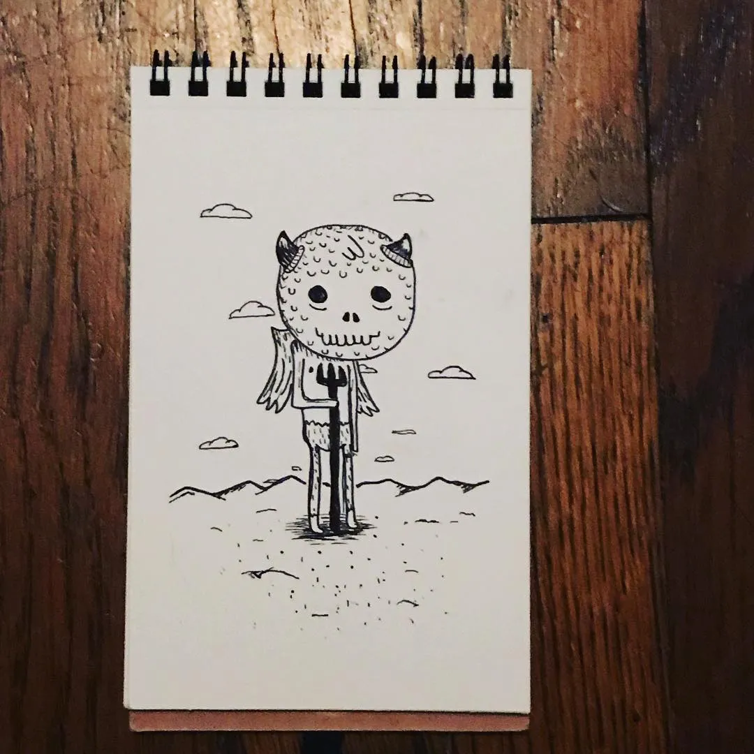 A black ink drawing on white paper depicts a stylized skull figure standing in a desert landscape, accompanied by small floating clouds.