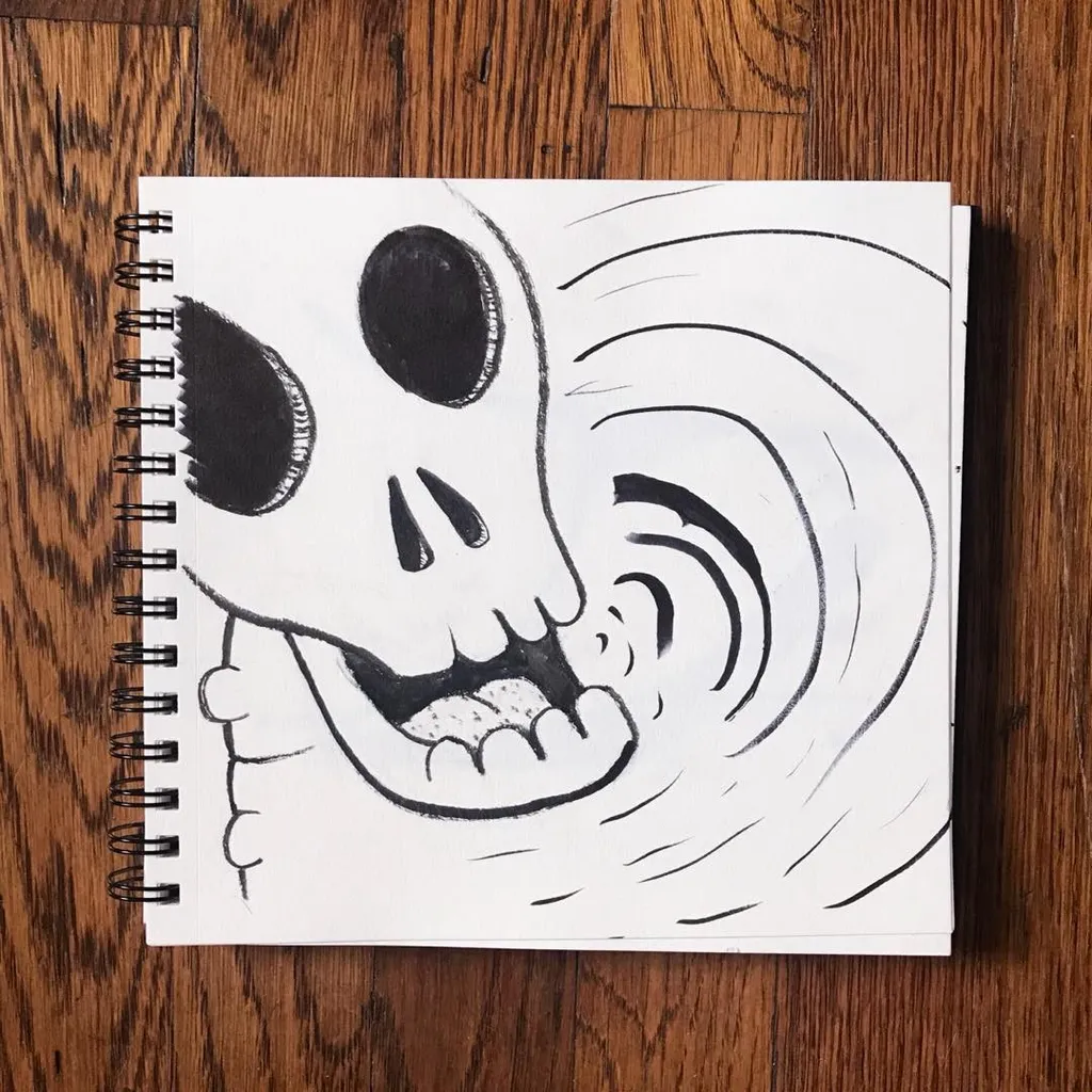 A black ink drawing of a stylized skull on white paper, featuring wide eye sockets and an open mouth, surrounded by radiating curved lines that create a dynamic spiral effect.