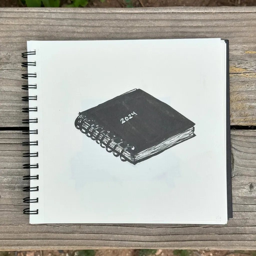 A drawing of a dark spiral notebook marked 2024, centered on white paper that rests on a textured brown wooden surface.