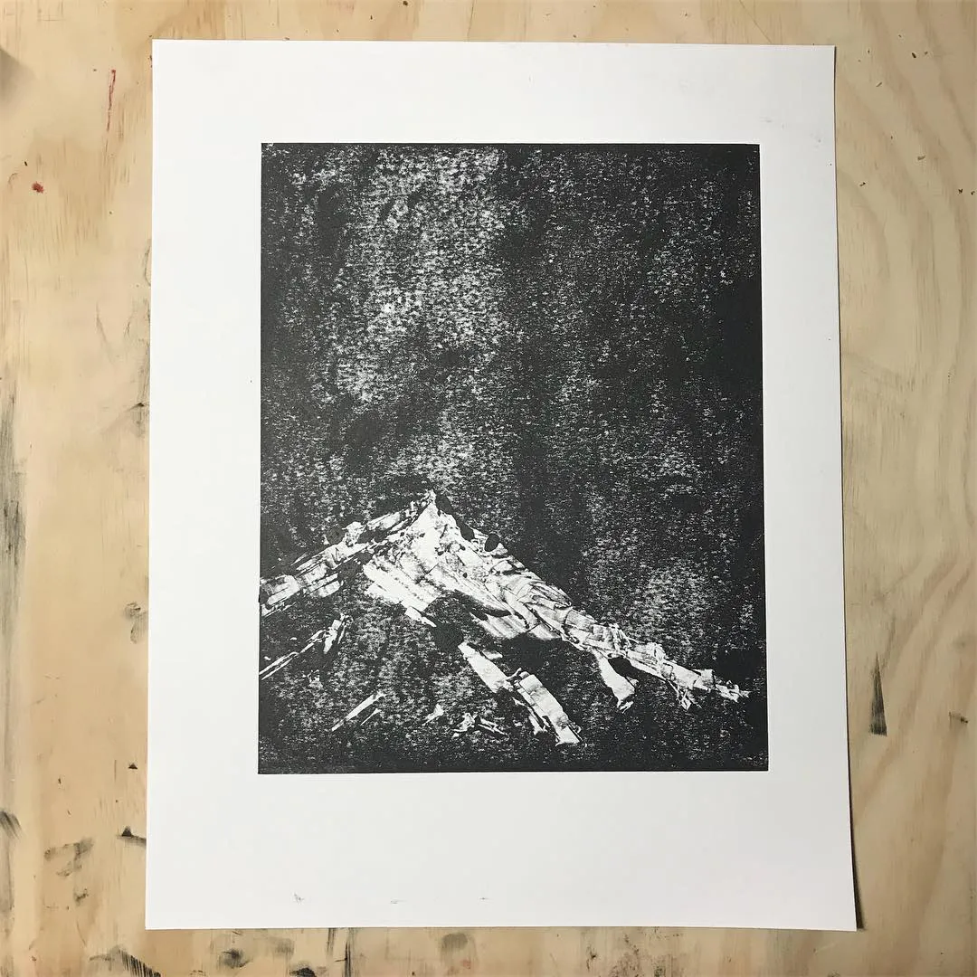A monochromatic composition featuring a sharply defined, white mountain peak dominating the bottom third, set against a dense, speckled black background.