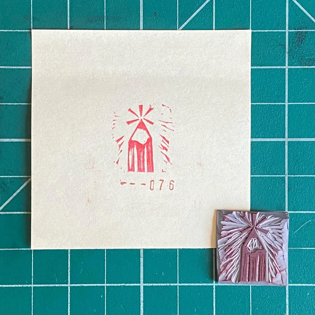 On a teal grid, a cream square features a red abstract drawing and the number --076, next to a small, textured square piece in pink and white with a similar abstract design.
