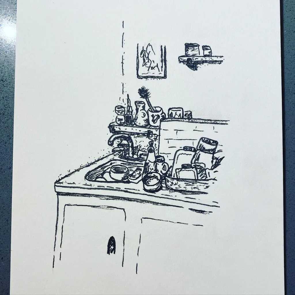 A black ink sketch on white paper depicts a cluttered kitchen counter with various vessels and utensils, complemented by two smaller, framed sketches positioned above the main scene.