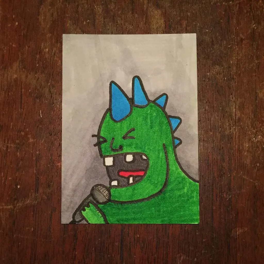 A stylized green creature with blue spikes and sharp teeth holds a microphone, drawn on light paper set against a dark wood surface.