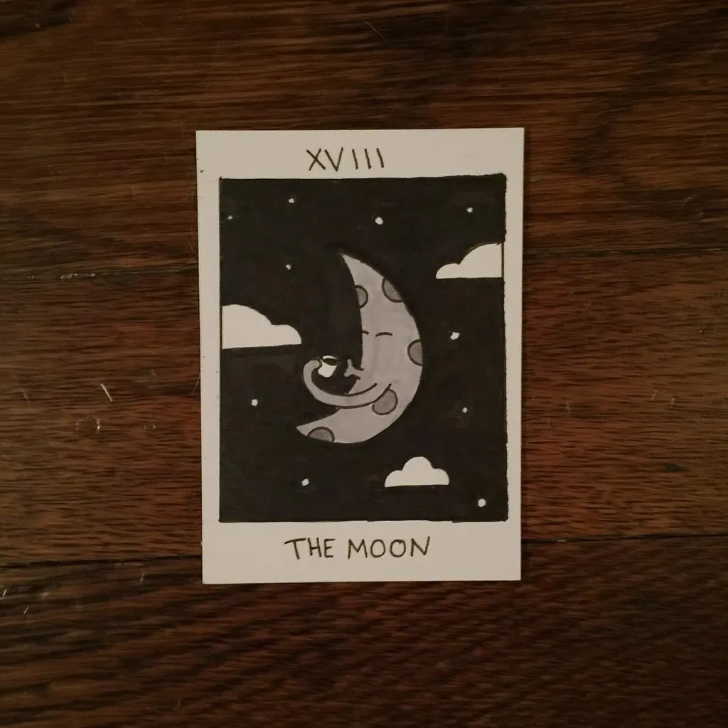 Black and white illustration on a card featuring a smiling crescent moon character in a starry night sky, framed by a border, with the Roman numerals XVIII and the title THE MOON printed below.