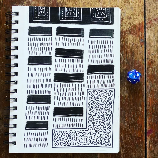 Black ink patterns fill a sketchbook page, featuring organized rows of dashed lines and solid bars, contrasting with a section of dense scribbling, placed on wood next to a blue die.
