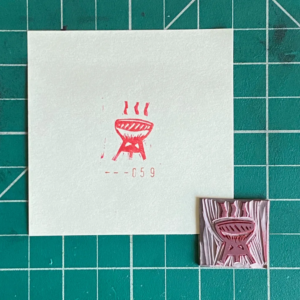 On a teal grid, a white card displays a red drawing of a grill and the code 059, next to a small, textured pink rectangle featuring a raised grill design.