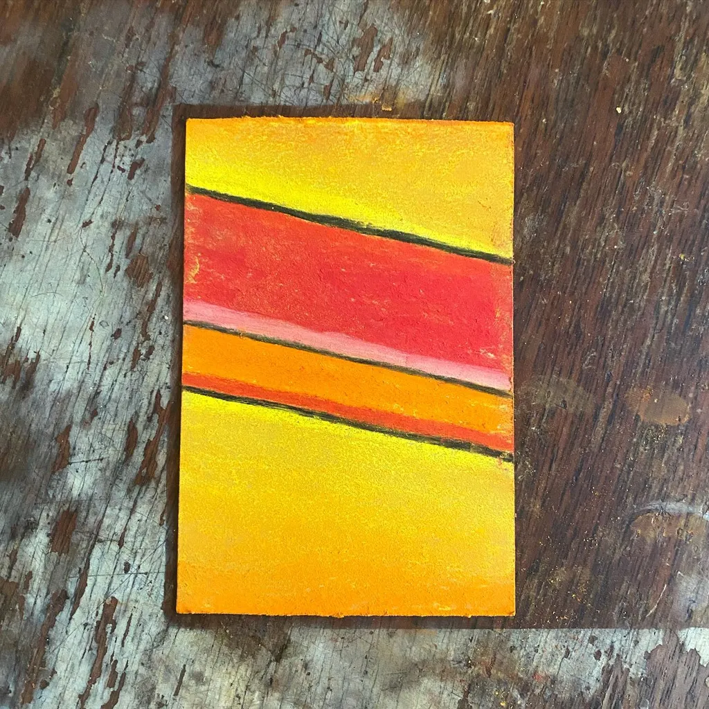 A bright yellow rectangle with three horizontal bands of red and orange stripes, set against a dark, textured wooden background.