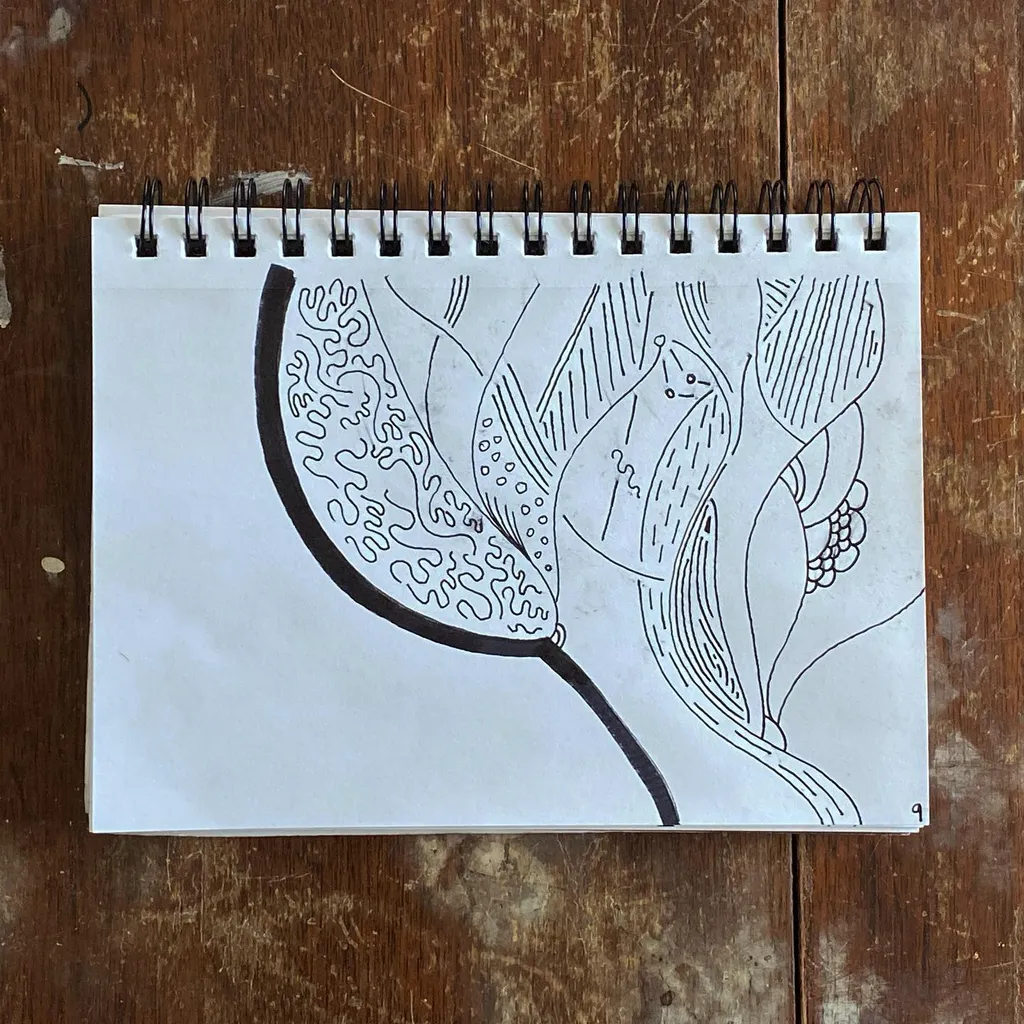 A black ink drawing on a spiral notepad features several stylized, overlapping, organic forms filled with intricate patterns, including dots, hatching, and curved lines.