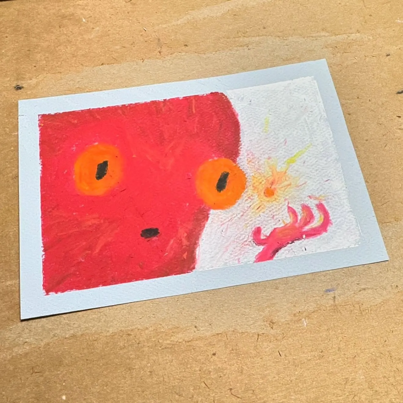 A bright red, stylized face with large orange eyes occupies the left side of a textured white background, balanced by a small, pink, claw-like shape on the right.
