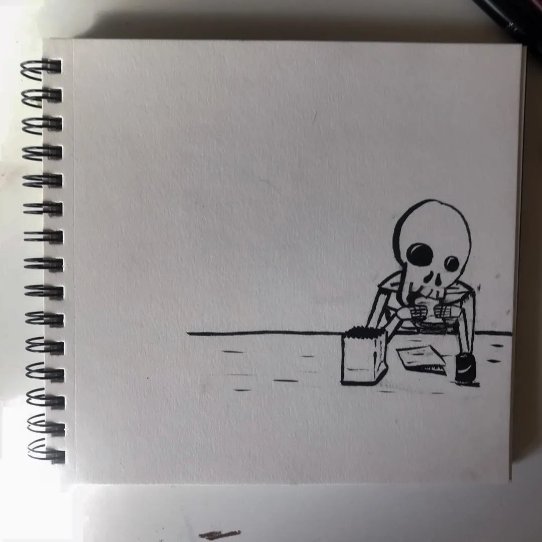 A black line drawing of a skeleton seated at a table on a page in a spiral sketchbook, with the figure positioned in the lower right corner.