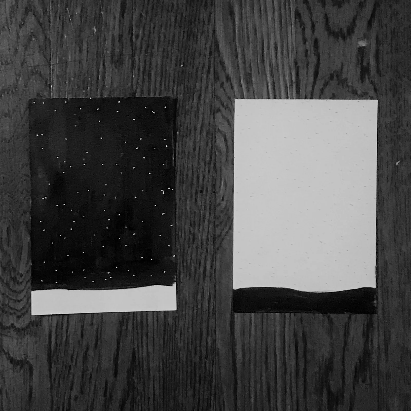 Two rectangular panels are displayed side by side: the left panel is dark with scattered white dots and a white lower band, contrasting with the right panel, which is white with a solid black lower band.