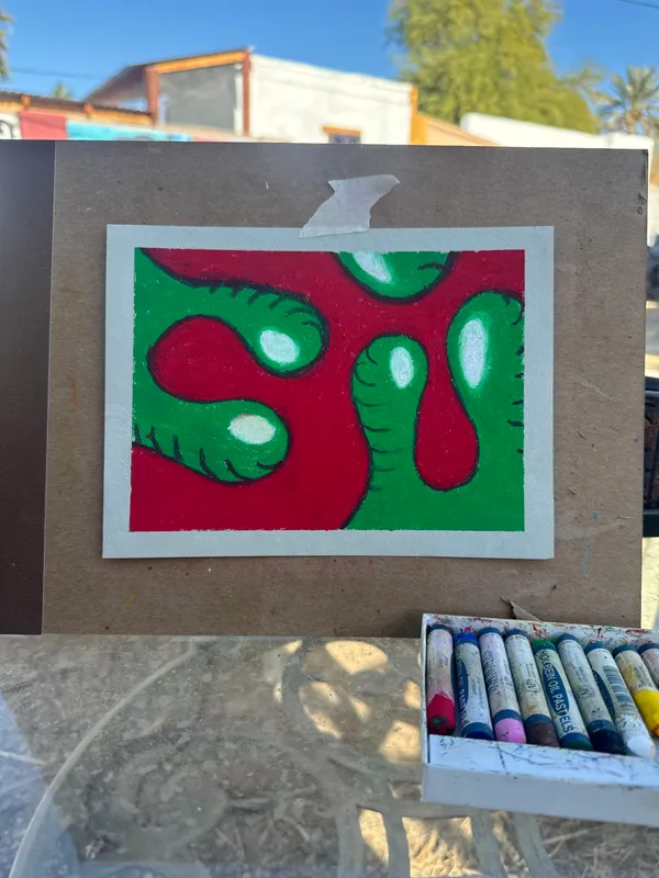 Abstract artwork featuring interlocking, organic shapes in bright red and green, which contain several white, rounded elements, displayed on a brown backing board.