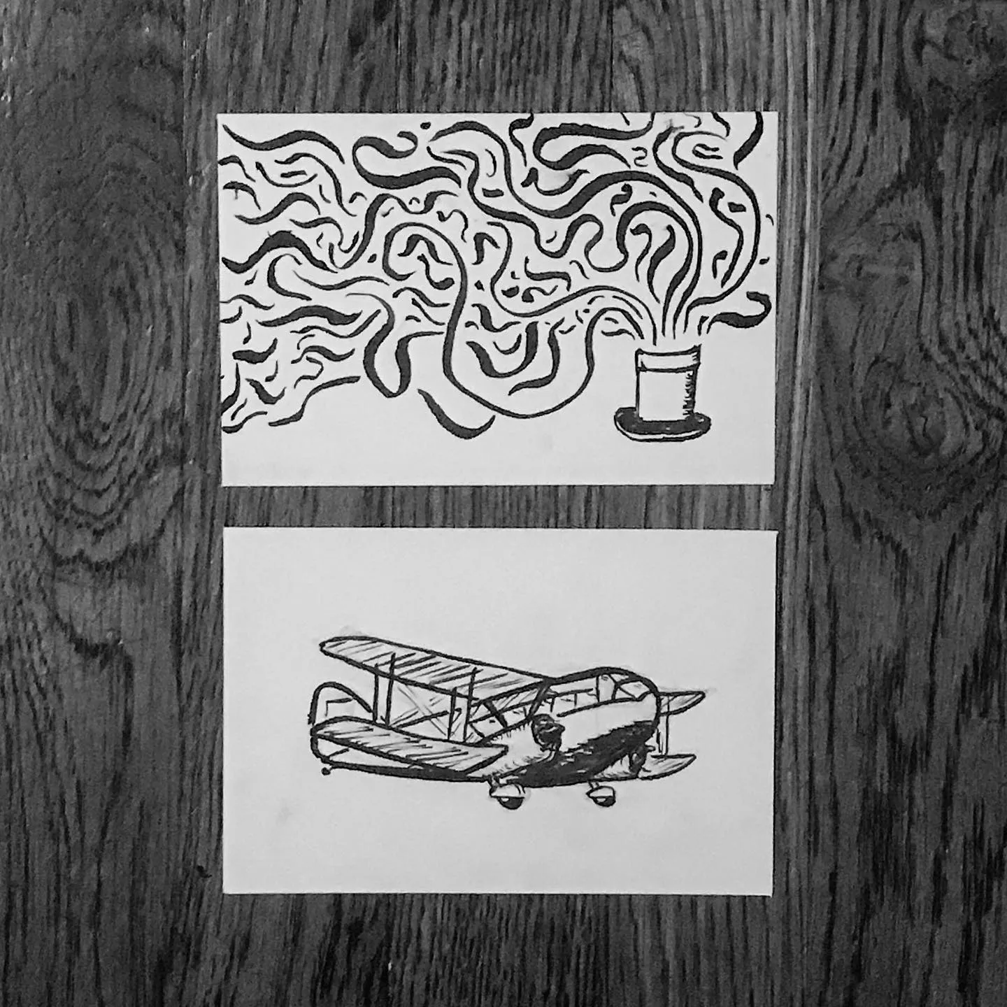 Two black and white drawings are stacked vertically; the upper drawing depicts swirling smoke from a pot, and the lower drawing shows a biplane.