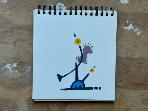 A balancing object with purple and blue tones. The object is balancing on a bright blue base. Small yellow dots decorate the tips of the balancing object.