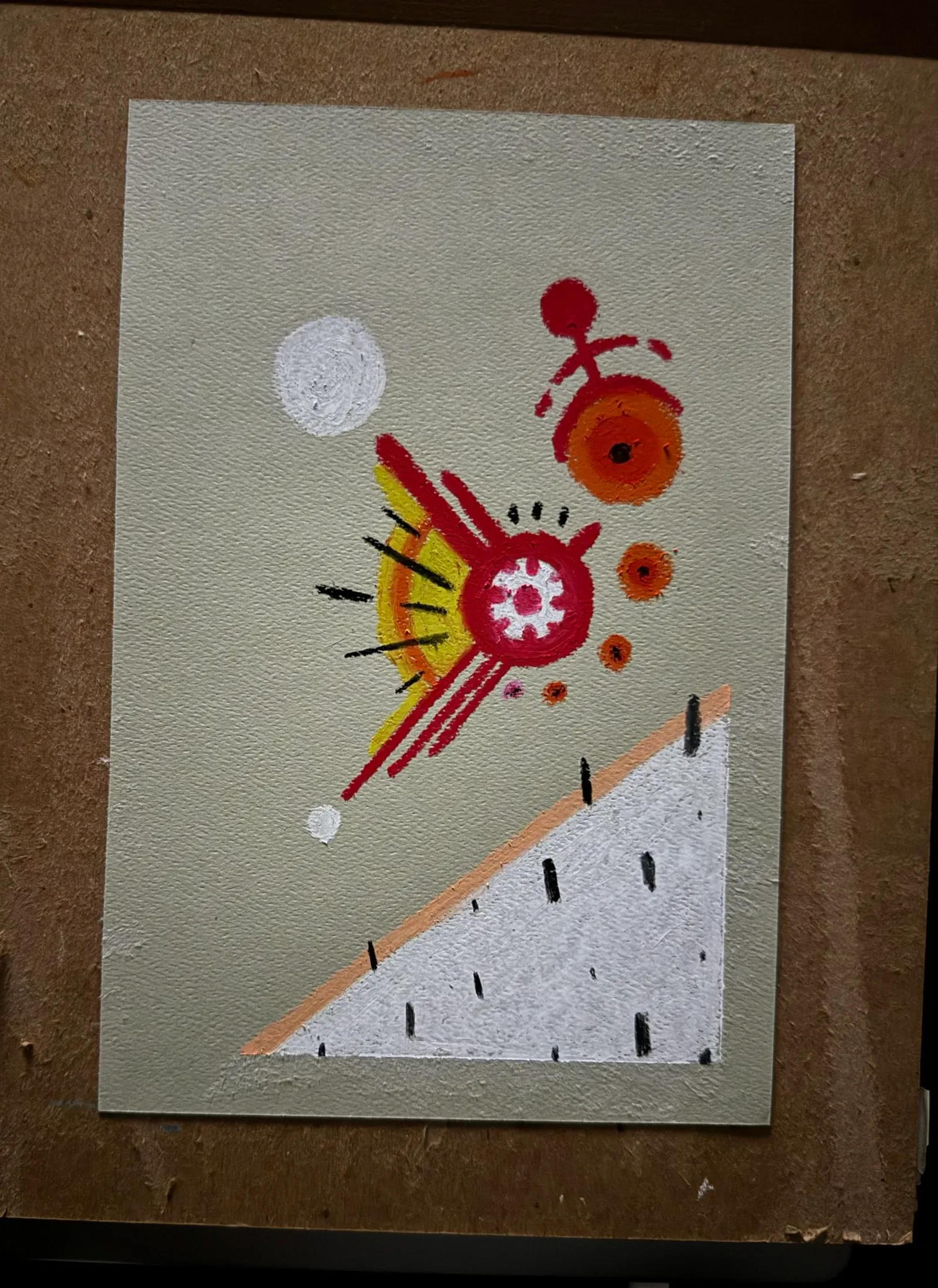 On a muted green background, a large white triangle occupies the bottom half, while the upper section features abstract red, orange, and yellow circular forms and radiating lines.