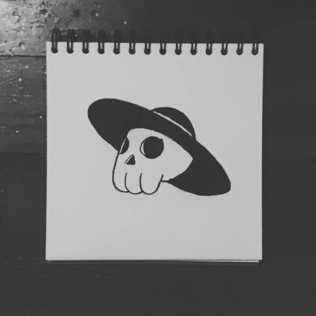A black and white drawing of a stylized skull wearing a wide-brimmed hat is centered on a white, spiral-bound notepad.