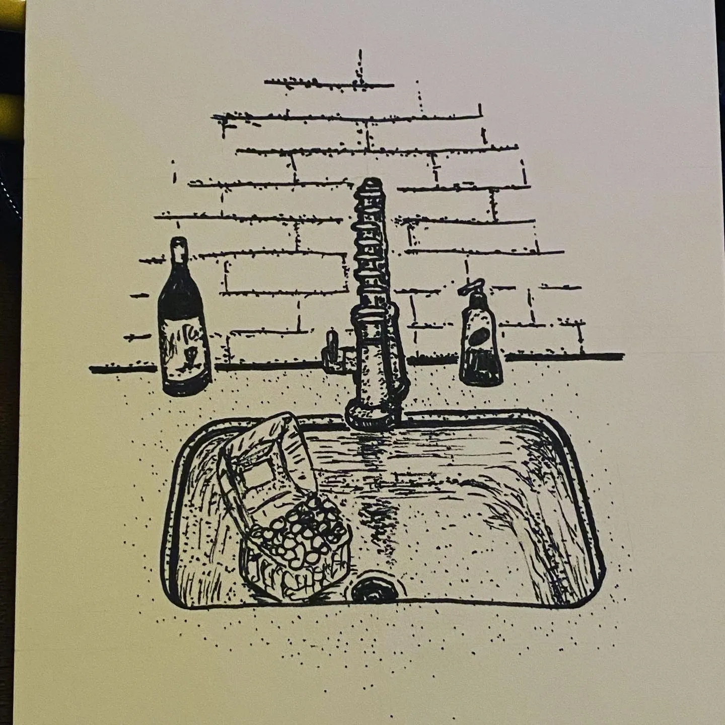 The drawing depicts a sink basin and brick backsplash, rendered in black ink with cross-hatching, showing a central faucet, three bottles, and soap items.