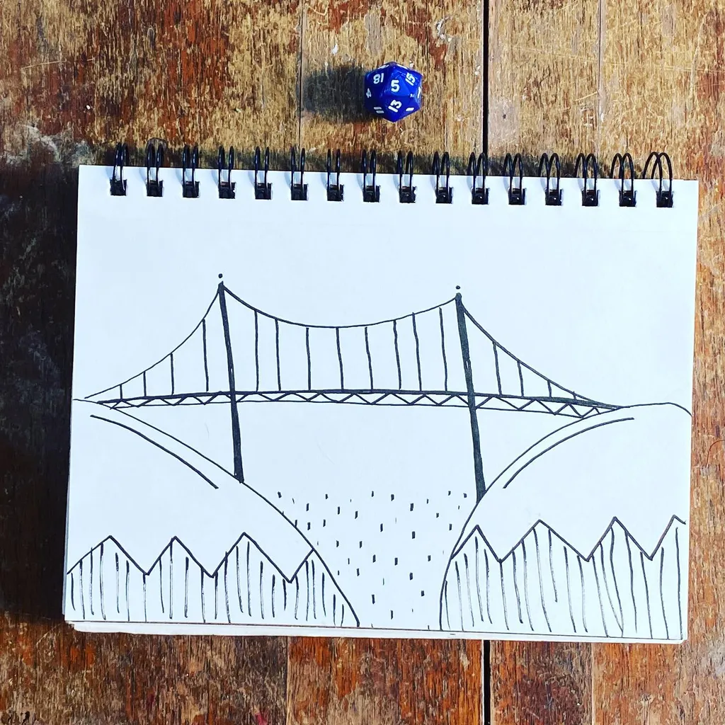 A black line drawing of a suspension bridge spanning a valley between rolling hills is centered on white paper, which sits on a textured wooden surface near a blue die.
