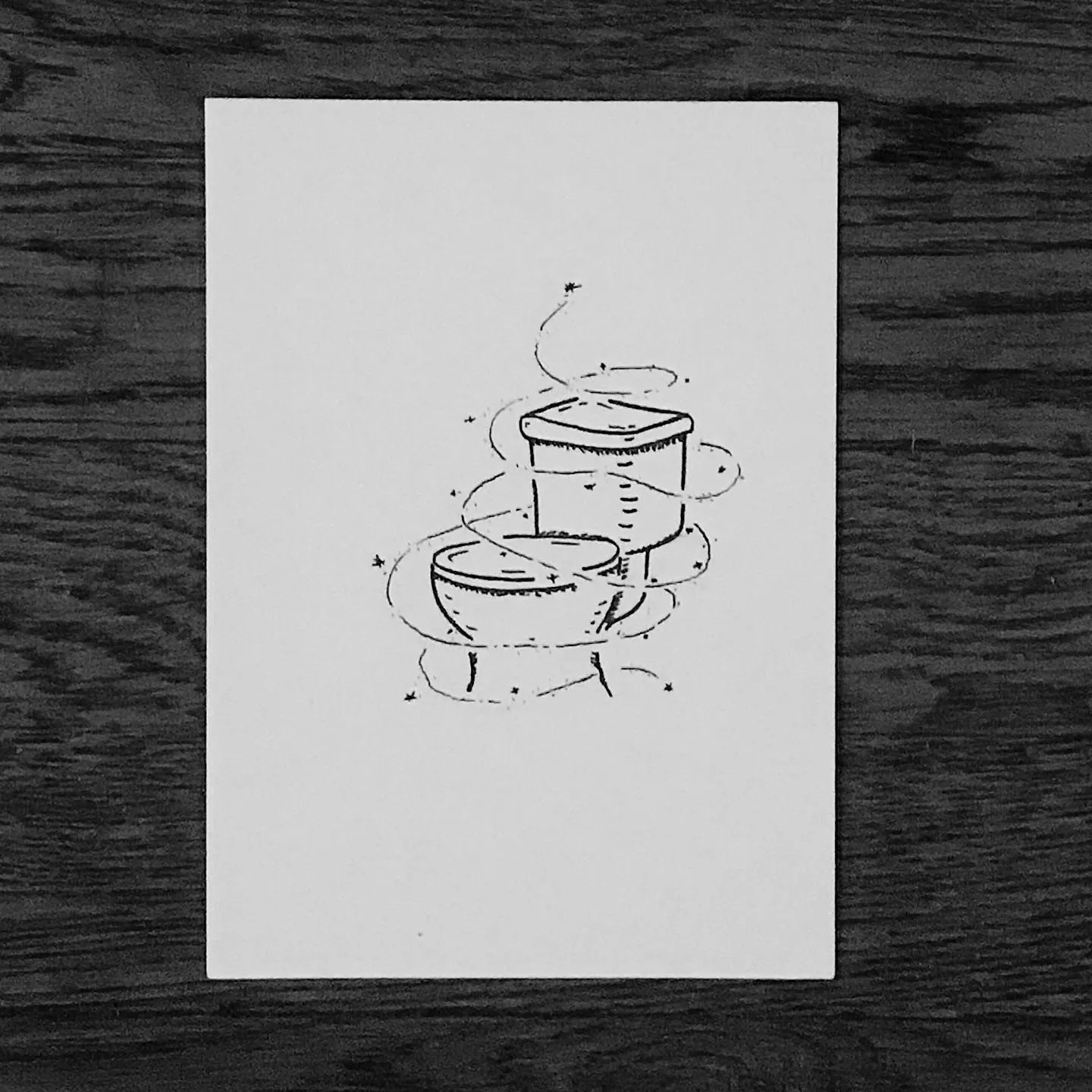 Black line drawing of three stacked vessels: a wide bowl base supporting two smaller, stacked cylindrical containers, with small asterisks scattered around the base.