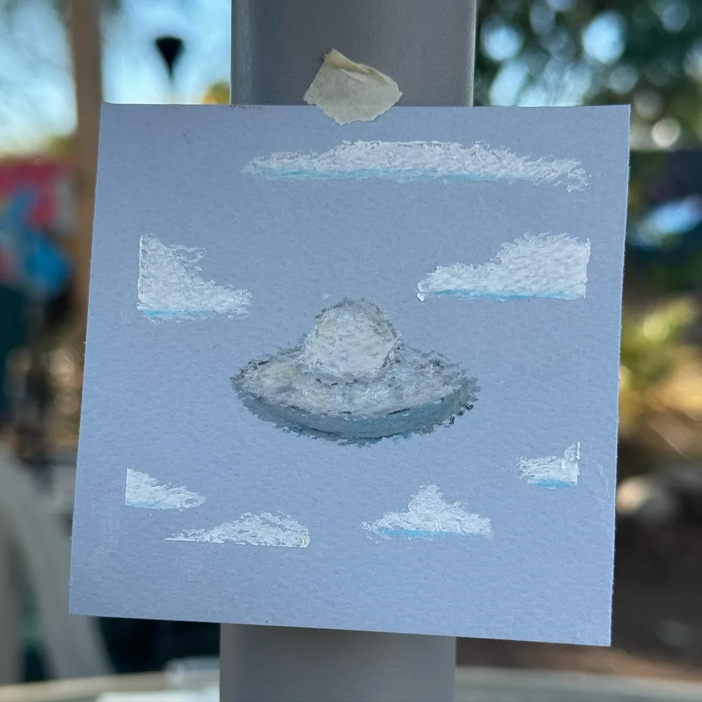 A light blue square features a central, textured, grayish-white cloud formation surrounded by smaller, white, horizontal cloud shapes.