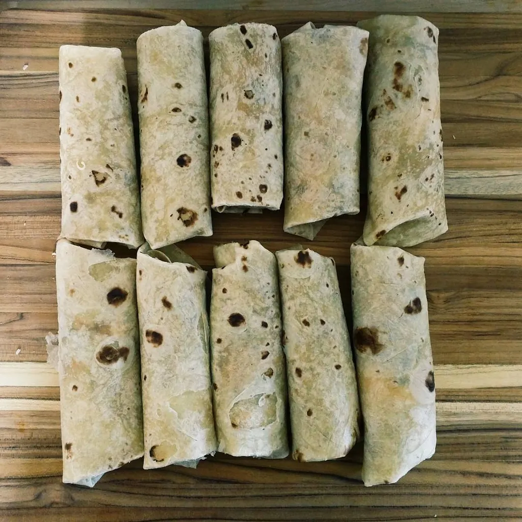 Six light tan, cylindrical objects are arranged in two rows on a wooden surface, displaying irregular golden-brown browning and visible wood grain texture.