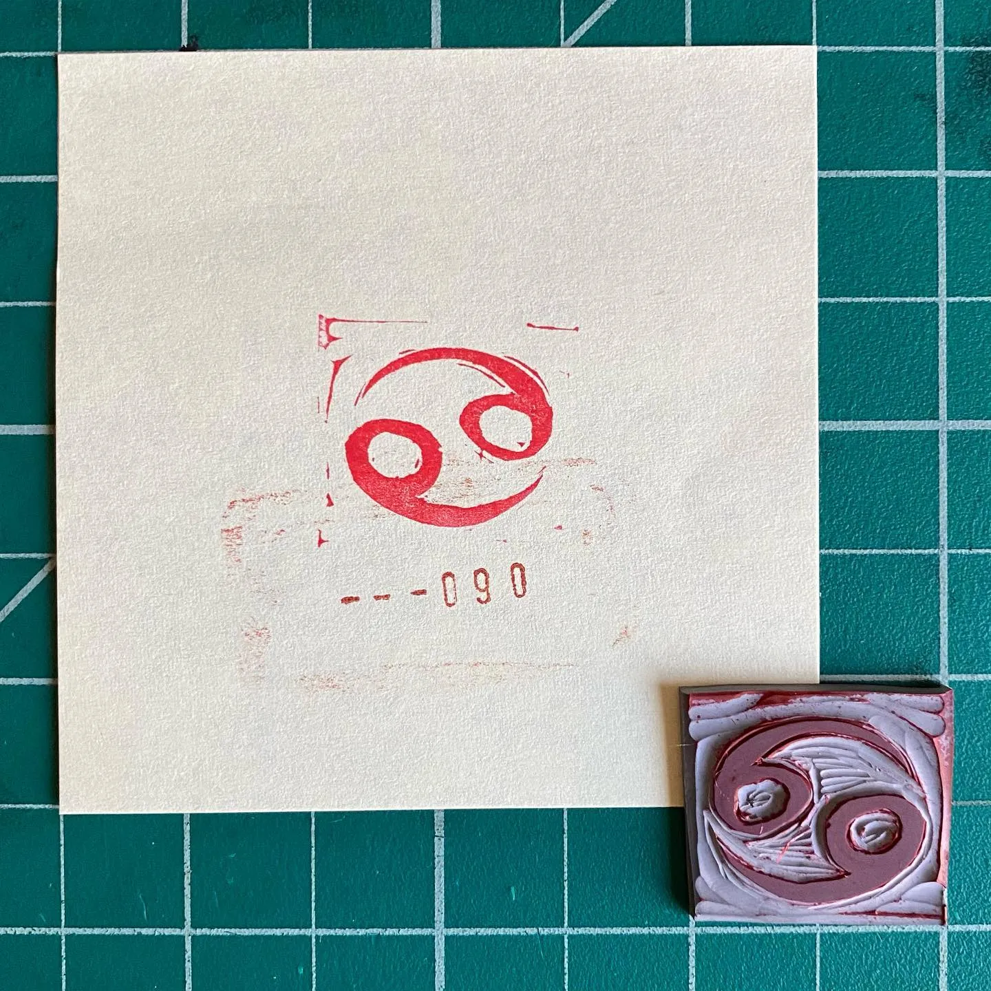 A cream square on a teal grid displays a red stylized loop and the numbers 0-90, next to a small, square piece featuring abstract swirls of pink and white.
