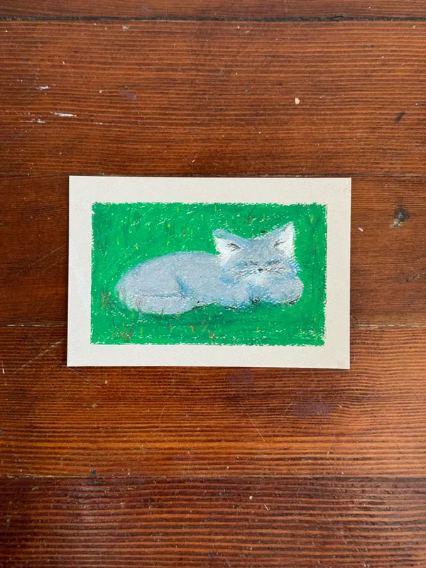 A stylized light blue animal rests on a solid green painted background, framed by a cream border.
